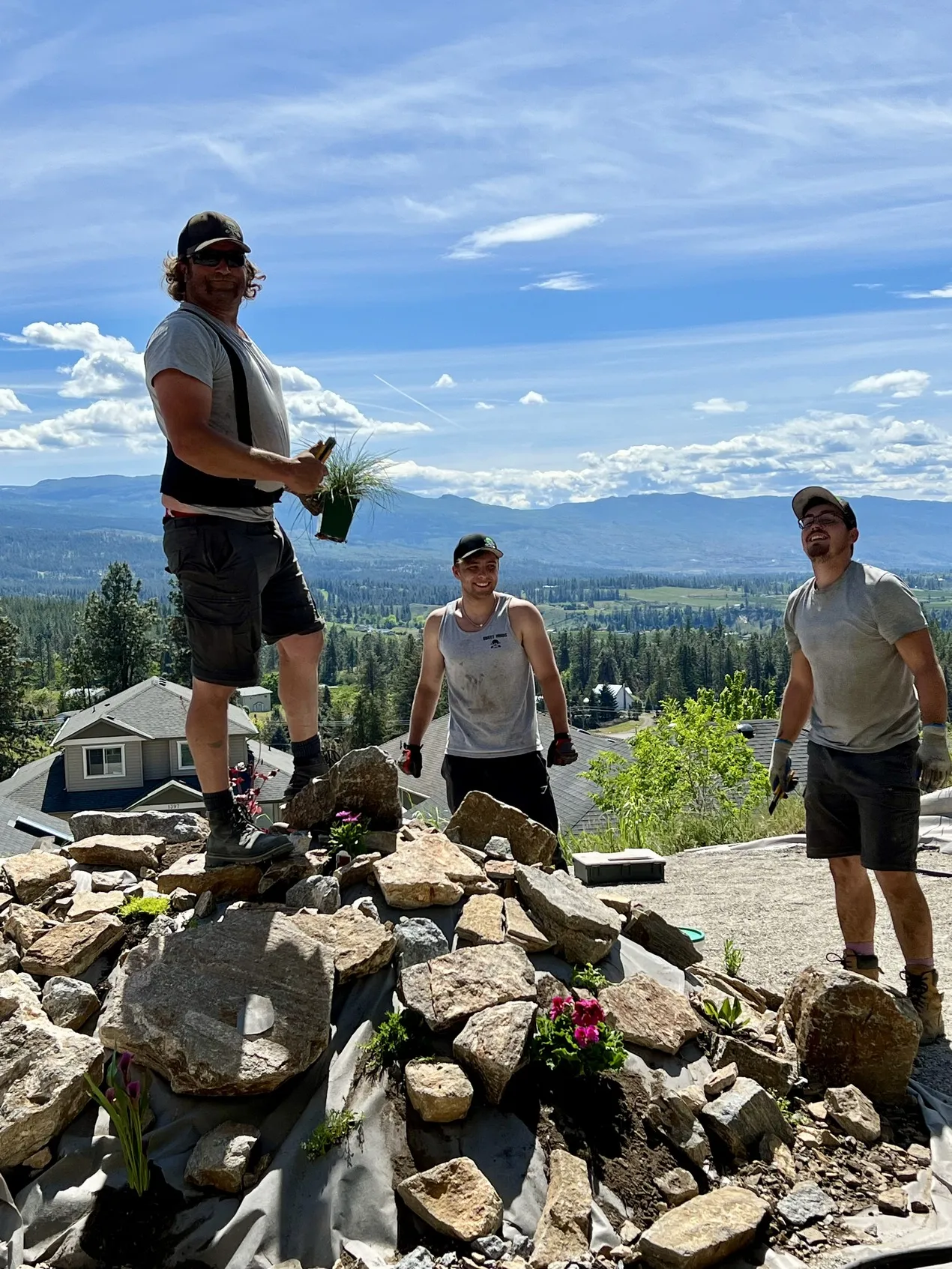 Sweet yards landscaping employees smiling on top of a picturesque landscape