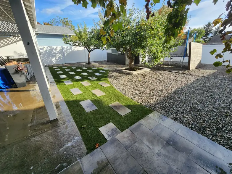 Yard with carefully placed stones and lemon trees in the background by sweet yards in Kelowna