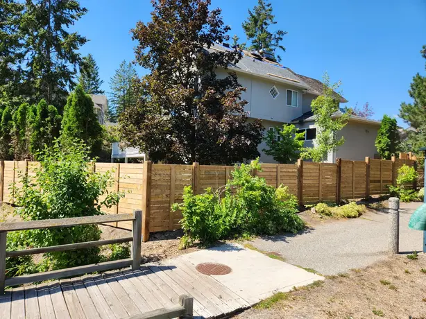 Wooden fence with shrubs done by sweet yards landscaping in Kelowna